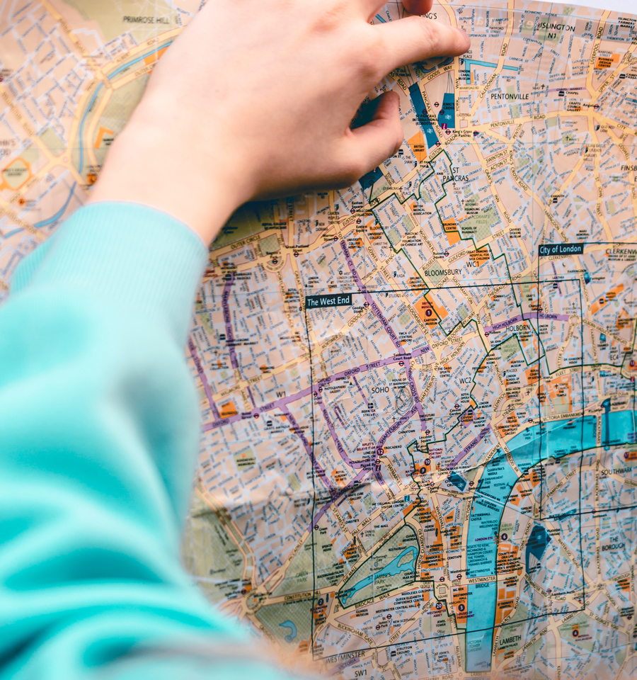 A person plotting a route using a paper map